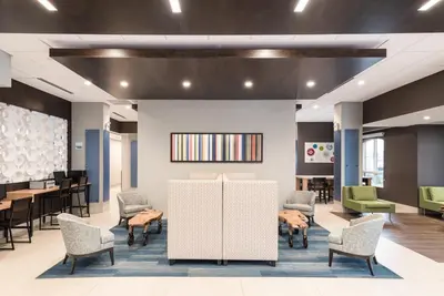a waiting area with chairs and tables in a lobby at Holiday Inn Express Hotel & Suites Milton by IHG in Milton