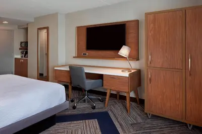 a hotel room with a desk with a bed and a television at Four Points by Sheraton Hamilton - Stoney Creek in Hamilton