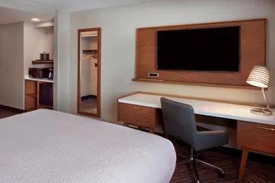 a hotel room with a bed and a desk with a television at Four Points by Sheraton Hamilton - Stoney Creek in Hamilton