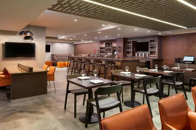 a restaurant with tables and chairs and a bar at Four Points by Sheraton Hamilton - Stoney Creek in Hamilton