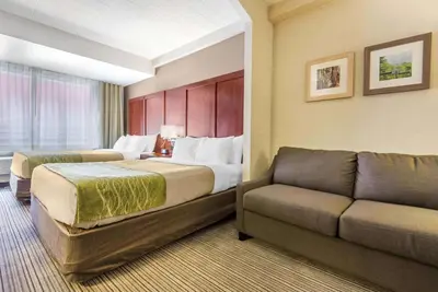 a hotel room with a bed and a couch at Comfort Inn & Suites in Collingwood