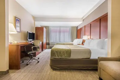 a hotel room with a bed and a desk at Comfort Inn & Suites in Collingwood