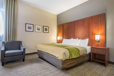 a hotel room with a bed and a chair at Comfort Inn & Suites in Collingwood