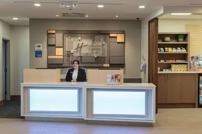 a woman sitting at a counter in a pharmacy at Holiday Inn Express & Suites - Belleville by IHG in Belleville