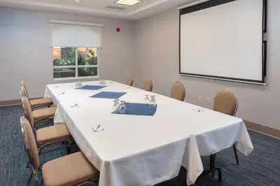a conference room with a table and a screen at Holiday Inn Express & Suites - Belleville by IHG in Belleville