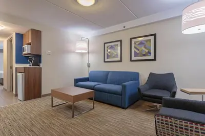 a waiting room with a blue couch and two chairs at Holiday Inn Express & Suites - Belleville by IHG in Belleville