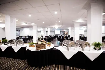 a banquet hall with black and white tables and chairs at Cambridge Hotel and Conference Centre in Cambridge