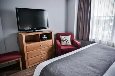 a hotel room with a bed and a flat screen tv at Cambridge Hotel and Conference Centre in Cambridge