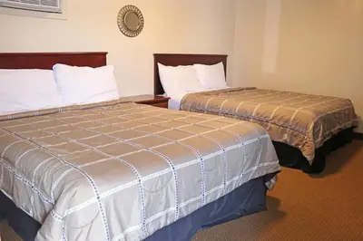 two beds sitting next to each other in a room at The Falls Family Lodge in Niagara Falls