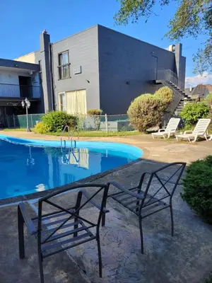 a swimming pool with a bench in front of a building at 7 Nights Stay in Niagara Falls