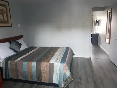 a bedroom with a bed with a striped blanket on it at 7 Nights Stay in Niagara Falls