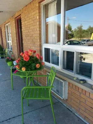 a green table with a vase of flowers on it at All Tucked Inn in Waubaushene