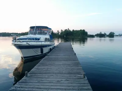 a boat is docked at a dock in the water at All Tucked Inn in Waubaushene