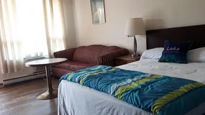a hotel room with a bed and a couch at All Tucked Inn in Waubaushene