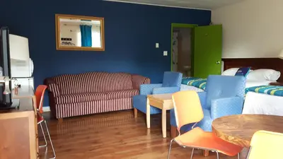 a living room with a couch and chairs and a table at All Tucked Inn in Waubaushene