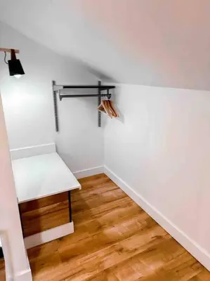 a white room with a bench and a wooden floor at Etherington Suites in Elora