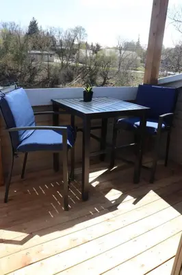 a table and chairs on a porch with a potted plant at Etherington Suites in Elora
