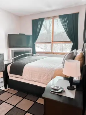 a bedroom with a bed and a table with a lamp at Etherington Suites in Elora