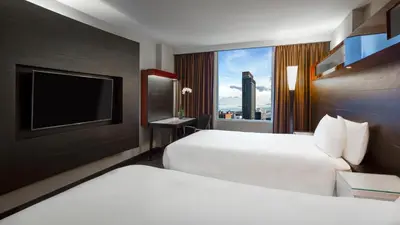 a hotel room with two beds and a television at Hyatt Regency Toronto in Toronto