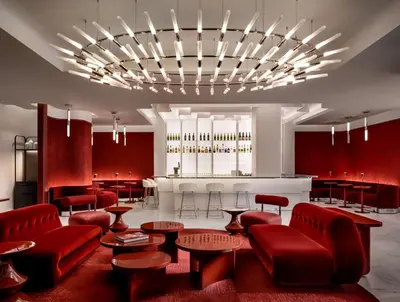 a lobby with red chairs and tables and a bar at Revery Toronto Downtown, Curio Collection by Hilton in Toronto