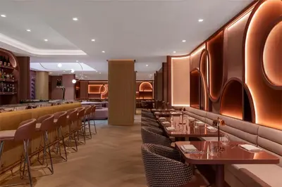 a restaurant with tables and chairs and a bar at Revery Toronto Downtown, Curio Collection by Hilton in Toronto