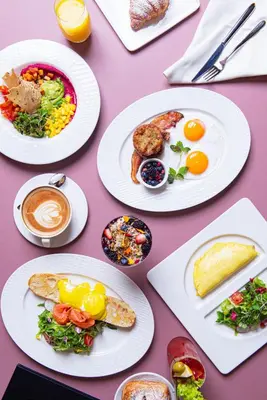 a table topped with plates of breakfast foods and coffee at Revery Toronto Downtown, Curio Collection by Hilton in Toronto