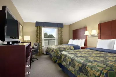 a hotel room with two beds and a flat screen tv at Travelodge by Wyndham Oshawa Whitby in Oshawa