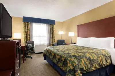 a hotel room with a bed and a television at Travelodge by Wyndham Oshawa Whitby in Oshawa