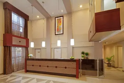 a lobby with a reception desk in a building at Travelodge by Wyndham Oshawa Whitby in Oshawa