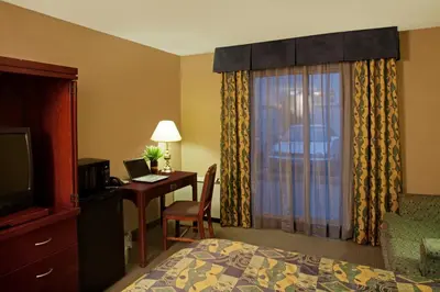 a hotel room with a bed and a desk and a television at Travelodge by Wyndham Oshawa Whitby in Oshawa