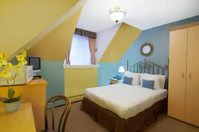 a bedroom with a bed with blue and yellow walls at Victoria's Mansion Guest House in Toronto