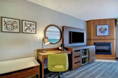 a room with a desk with a television and a chair at Hampton Inn & Suites Guelph in Guelph