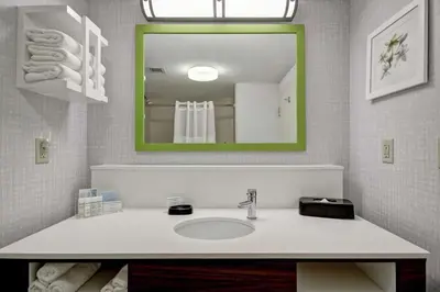 a bathroom with a sink and a green mirror at Hampton Inn & Suites Guelph in Guelph