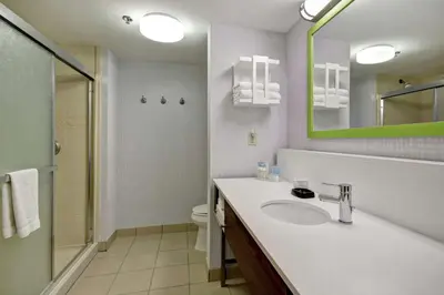 a bathroom with a sink and a mirror and a toilet at Hampton Inn & Suites Guelph in Guelph