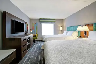 a hotel room with two beds and a flat screen tv at Hampton Inn & Suites Guelph in Guelph