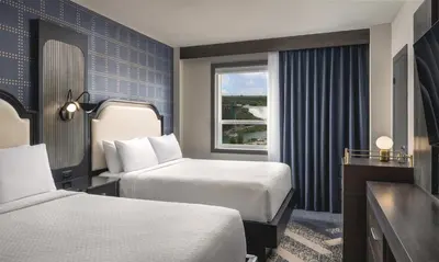 a hotel room with two beds and a window at The Brock Niagara Falls Fallsview, Tapestry by Hilton in Niagara Falls