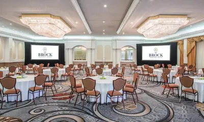 a conference room with tables and chairs and two screens at The Brock Niagara Falls Fallsview, Tapestry by Hilton in Niagara Falls