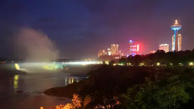 a city skyline at night with a river and buildings at Holiday Inn Niagara Falls-By the Falls by IHG in Niagara Falls