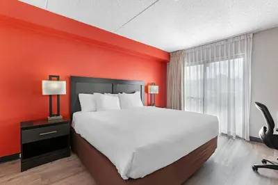 a bedroom with a large bed and a red wall at Quality Inn & Suites 5585 Ambler Drive Mississauga Ontario in Mississauga