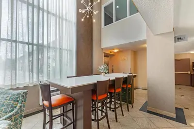 a kitchen with a table and chairs and a large window at Quality Inn & Suites 5585 Ambler Drive Mississauga Ontario in Mississauga