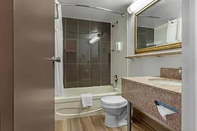 a bathroom with a toilet and a sink and a mirror at Quality Inn & Suites 5585 Ambler Drive Mississauga Ontario in Mississauga