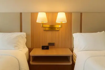 a room with two beds and a table with a clock on it at Holiday Inn & Suites Mississauga West - Meadowvale by IHG in Mississauga