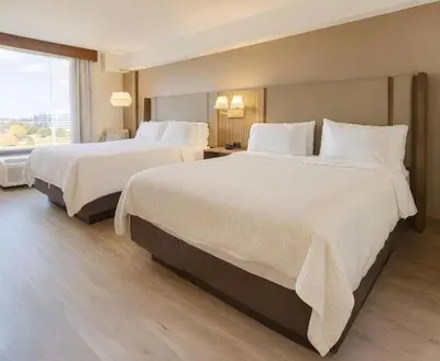 a hotel room with two beds and a window at Holiday Inn & Suites Mississauga West - Meadowvale by IHG in Mississauga