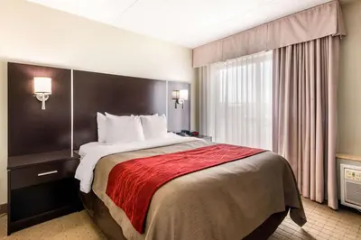 a hotel room with a bed and a window at Comfort Inn Airport West in Mississauga