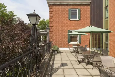 a patio with chairs and umbrellas next to a building at Spencer Hotel & Conference Centre in London