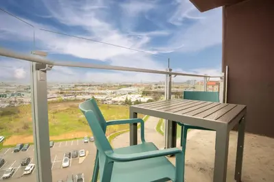 a table and chairs on a balcony with a view of a city at Sandman Signature Toronto Airport Hotel in Toronto