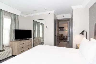 a bedroom with a white bed and a television at Sandman Signature Toronto Airport Hotel in Toronto