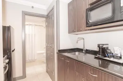 a kitchen with a sink and a microwave at Sandman Signature Toronto Airport Hotel in Toronto