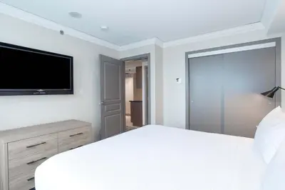 a bedroom with a white bed and a flat screen tv at Sandman Signature Toronto Airport Hotel in Toronto