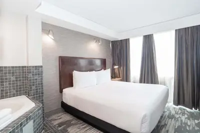 a hotel room with a bed and a bath tub at Sandman Signature Toronto Airport Hotel in Toronto
